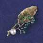 Brooch-pendant Sprig with green crystals, white bead, gold-tone and silver-tone metal 76x33mm+