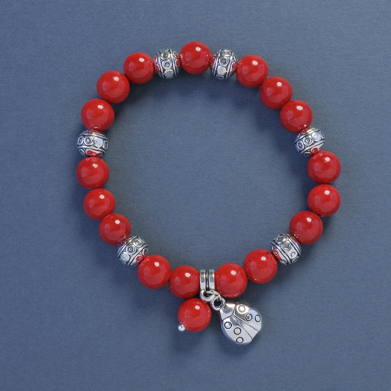 Coral Bracelet (pressed), diameter 9 mm ±, length 18 cm ±, elastic with a Ladybug charm