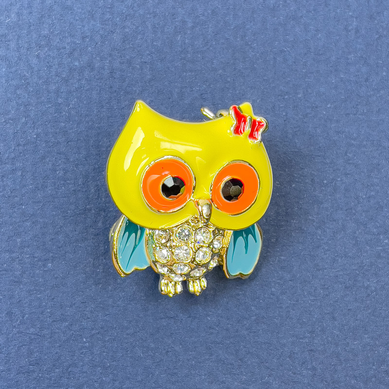 Owl brooch pendant with white crystals, yellow and blue enamel, gold-tone metal, diameter 20mm, length 25mm