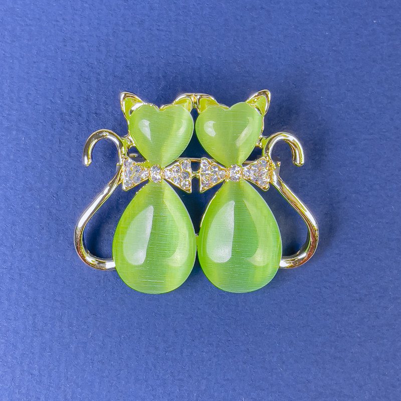 Brooch 'Cats' with green Cat's Eye white rhinestones gold-tone metal, diameter 31x38mm +