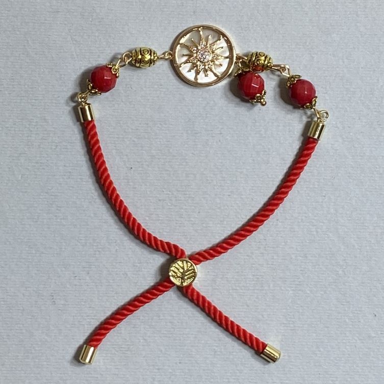Textile bracelet, 5.5 mm diameter +/-, adjustable drawstring, coral faceted bead 8 mm +/-, with a gold-tone metal insert, 17 mm diameter +/-