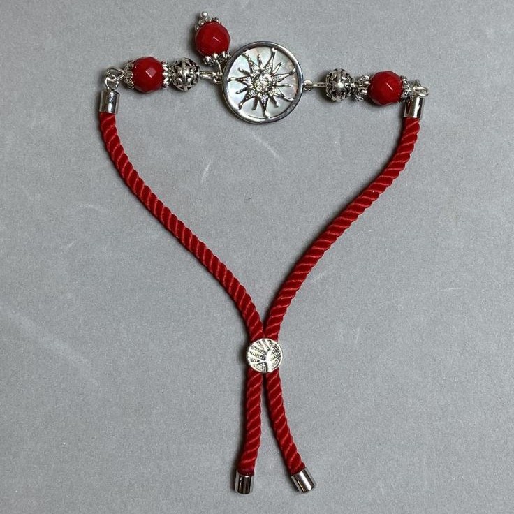 Textile bracelet, 5.5 mm diameter ±, adjustable; coral faceted bead 8 mm ±, with metal insert, 17 mm diameter ±, silver-colored metal