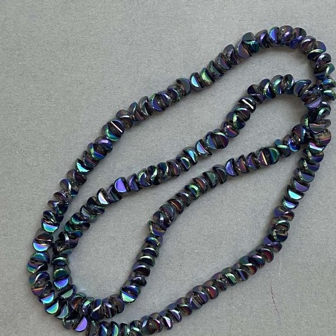 Crystal beads in 'Swarovski' style, white with a 'gasoline tint', diameter approximately 6×3.5 mm, length about 49 cm on beading thread