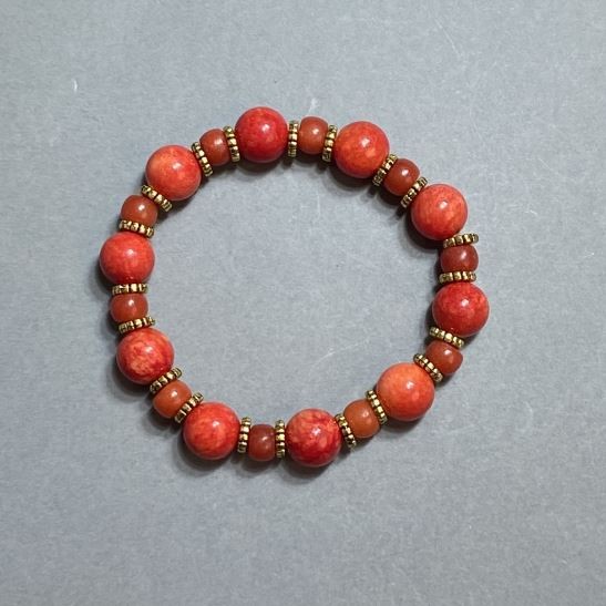 Bracelet with imitation coral beads (10 mm) and rondelles 7×5 mm, with metal inserts, 18 cm stretch