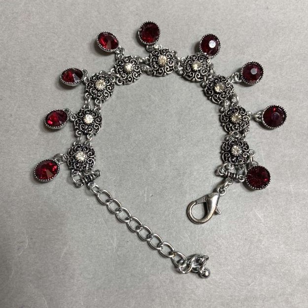 Bracelet with red crystals and pendants, length 18–23 cm, silver-tone metal