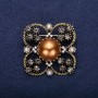 Brooch 'Order of Beauty' with pearl bead centerpiece and crystals, color brown, gray, white, 42×51 mm, yellow metal