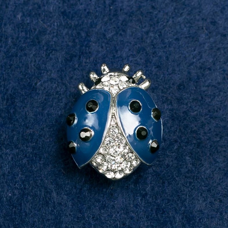 (20/25 mm) Sun-shaped brooch in light metal, adorned with stones, blue enamel