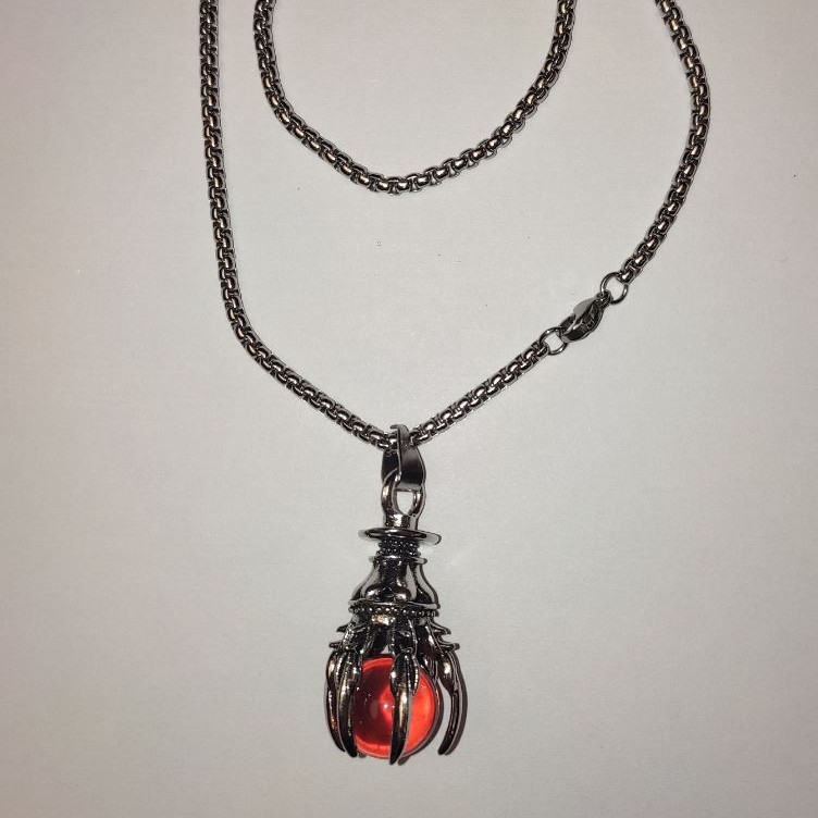 Pendant 'Ball in the Paw' orange 40x18 mm on a chain, length about 70 cm, silver-toned metal