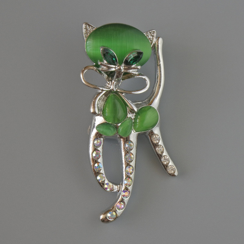 Cat-shaped brooch pendant with green cat's-eye, green crystals, pink and white rhinestones, silver-toned metal 25×55 mm