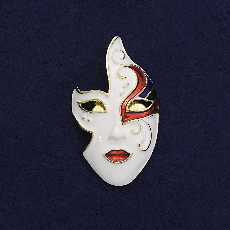 Mask Brooch with white, black, and red enamel on gold-tone metal, 40×23 mm, magnetic fastening