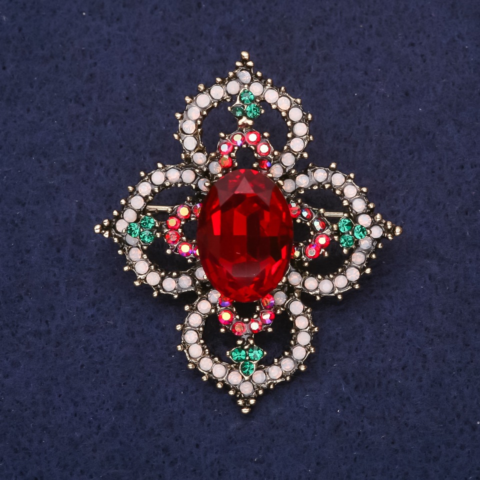 Brooch 'Order of Beauty' with a stone and rhinestones, color red, white, and green, 49x42 mm, yellow metal