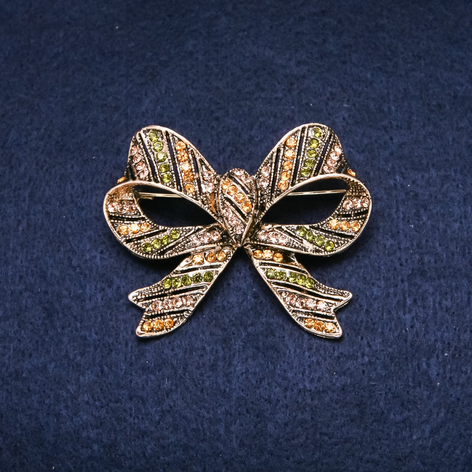 Brooch 'Accent Bow' 55x45mm with crystals, green and yellow, gold-tone metal