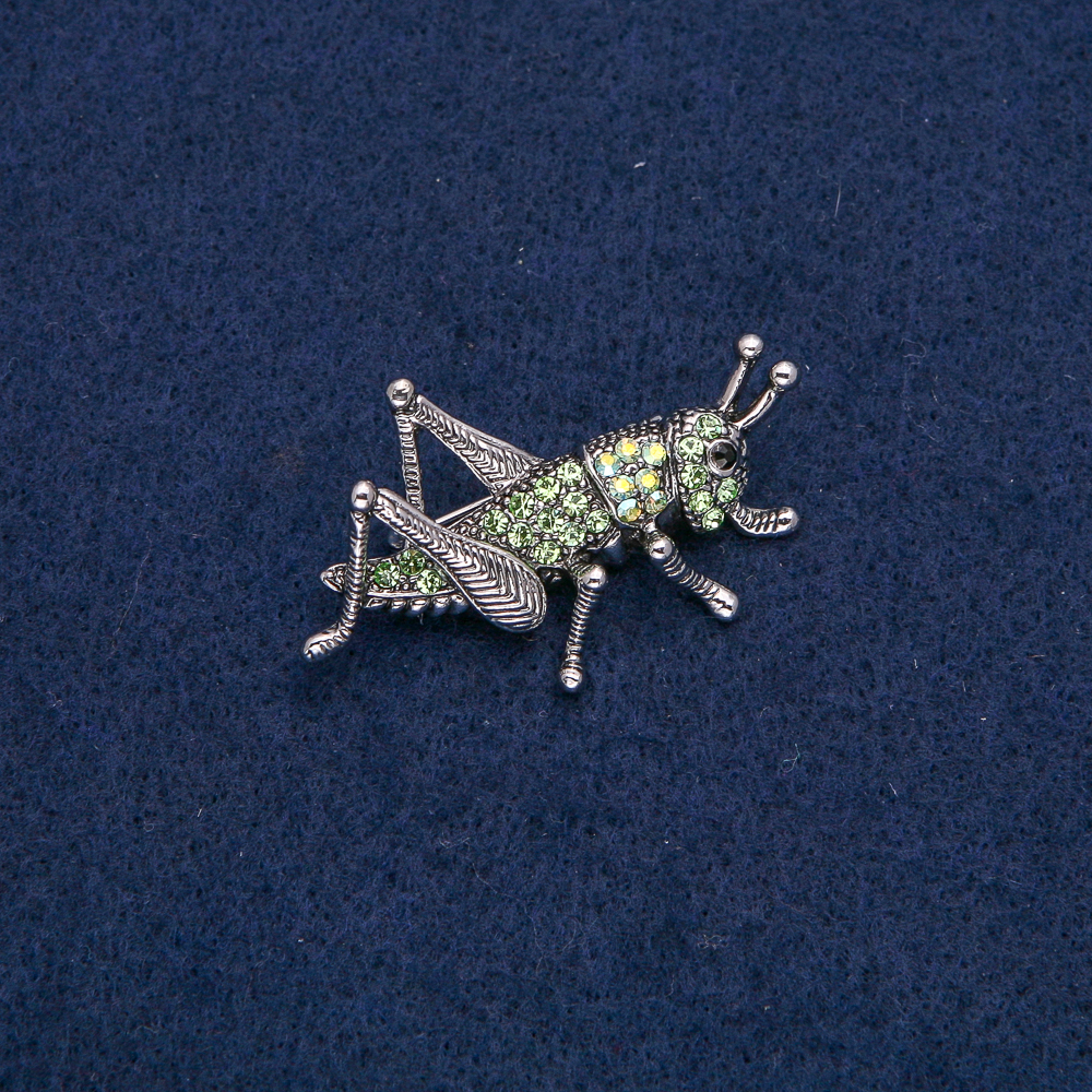 Brooch "Grasshopper" in silver-toned metal with black, green, and petrol rhinestones, 44x27mm +