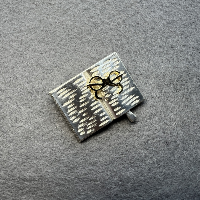 Brooch 'Book with Glasses' light gray enamel and golden enamel, silver metal 35x26mm